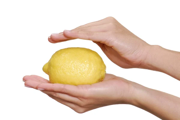 En ung kvinnlig hand håller en gul citron. — Stockfoto