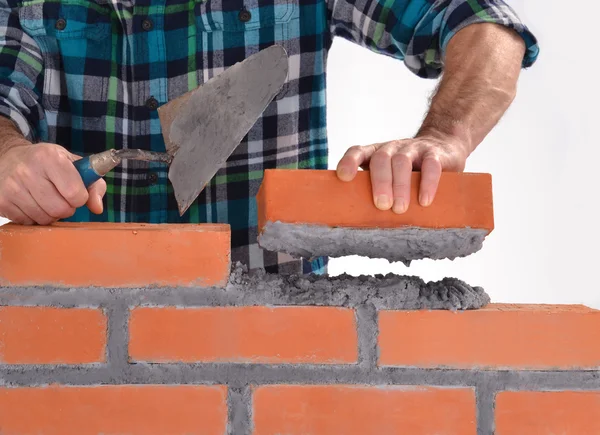 Constructor hand holding a brick and building a wall. — Stock Photo, Image