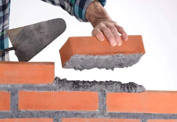 Konstruktor ręka trzyma cegły i budowa muru. — Zdjęcie stockowe