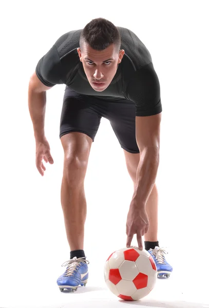 Jugador de fútbol sosteniendo una pelota de fútbol preparándose para tiro de penalti . — Foto de Stock