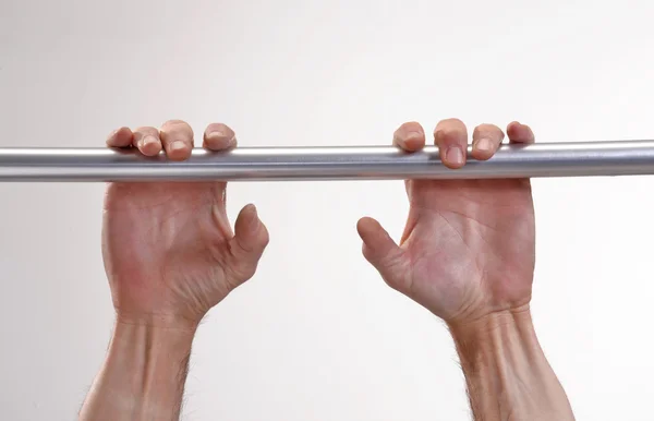 Hands hanging a metallic bar. — Stock Photo, Image