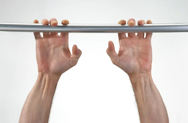 Hands hanging a metallic bar. — Stock Photo, Image