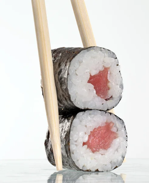 Holding tuna fish sushi roll with toothpicks — Stock Photo, Image
