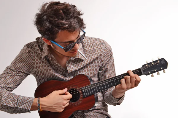 Nuori mies soittaa kitaraa — kuvapankkivalokuva