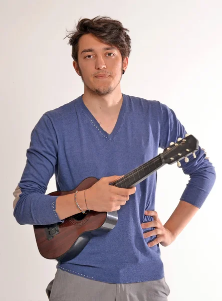 Jovem segurando e tocando guitarra . — Fotografia de Stock