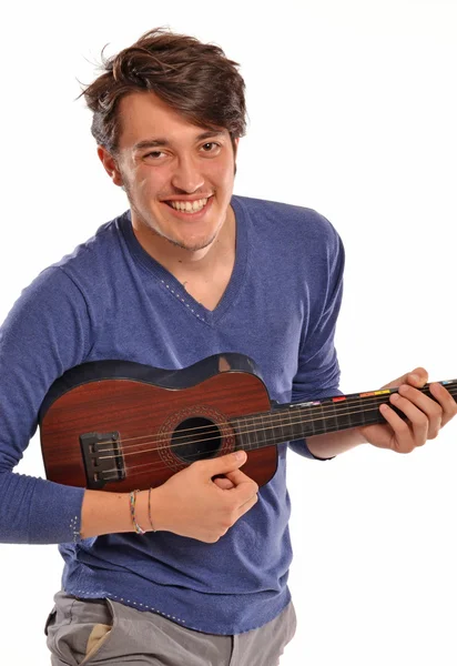 Jeune homme tenant et jouant une guitare . — Photo