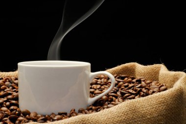 Bir fincan kahve ve sigara, kızarmış kahve taneleri, sade kahve torbası..