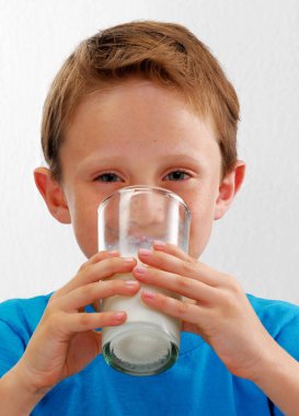 Mutlu çocuk bir bardak taze süt portresi içiyor..