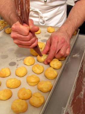 Pasta şefi kremalı pasta torbasıyla çikolata hazırlayıp yapıyor.