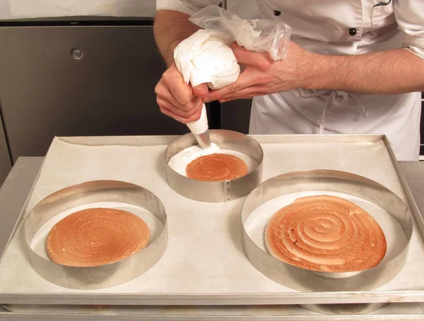 Pastry chef preparing and making cake using cream pastry bag