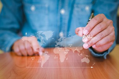 İş adamı akıllı telefonu 2022 'de iş büyümesini planlamak için kullanıyor. Teknolojiyle finans, pazarlama, satış artışı ve iş büyüme planlaması kavramları. Grafikleri kullanarak analiz et