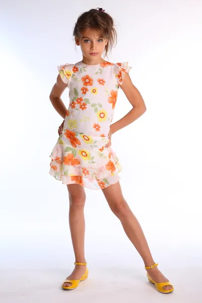 Маленькая девочка позирует в красочном платье — стоковое фото