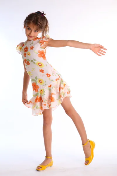 Malá dívka pózuje v barevných šatech — Stock fotografie
