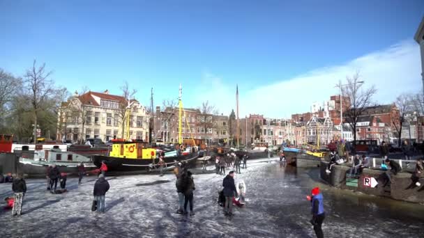 People ice skating on frozen canal in city center in Netherlands. Peoples making pictures, walking and skating on frozen canal in winter. Winter fun in cityGroningen. Netherlands. 14.02.2021. — 图库视频影像