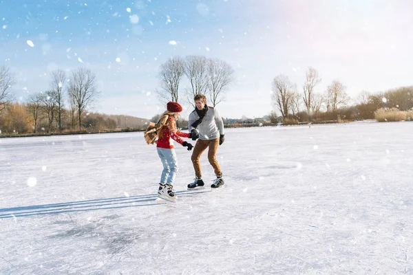 Pareja cariñosa en suéteres cálidos divirtiéndose en hielo. Mujer y hombre patinando sobre hielo al aire libre en un día soleado y nevado. Fecha activa en la arena de hielo en invierno Nochebuena. Actividades románticas y concepto de estilo de vida. Fotos De Stock Sin Royalties Gratis