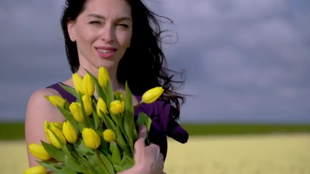 夏の美しい女性は、オランダ、オランダ、アムステルダム地域のカラフルなチューリップの花畑に立っています。オランダのチューリップ畑と魔法のオランダの風景旅行と春のコンセプト — ストック動画