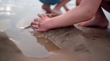 Children on summer vacation making on beach building sand castle together. kids playing with at tropical beach. enjoying playing warm sunny day on seashore. Family, Holiday and Travel concept