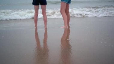 Tropik plajda oynayan güzel kızlar. Çocuklar sıcacık denizin tadını çıkarıyorlar. Çocuklar deniz kıyısında güneşli bir günde dalgalar üzerinde eğleniyor ve atlıyor. Yaz seyahati ve tatil kavramı