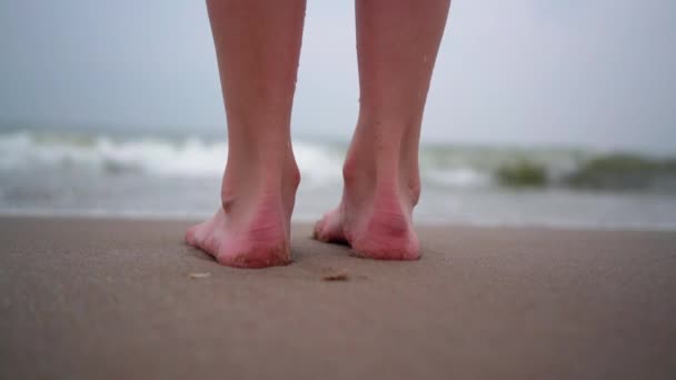人の裸の足の熱帯のビーチで歩くのを閉じる。熱帯のビーチで裸足で遊ぶ人々。海岸で暖かい晴れた日に海の水に飛び込む楽しみを持っています。夏の旅行と休暇のコンセプト — ストック動画