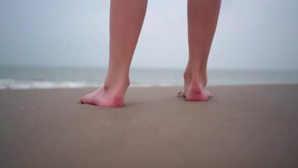 Blisko osoby boso chodzącej po tropikalnej plaży. Ludzie grający boso na tropikalnej plaży. Zabawa skacząc w wodzie morskiej w ciepły słoneczny dzień na brzegu morza. Koncepcja podróży letnich i wakacji — Wideo stockowe