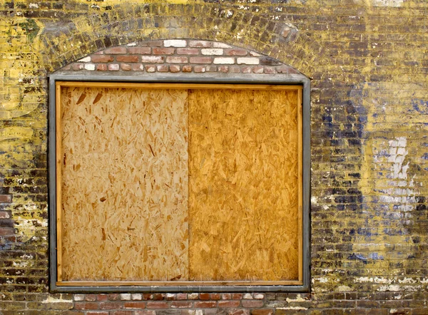 Старая кирпичная стена с заколоченным окном — стоковое фото