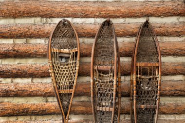 Snow shoes and a log cabin clipart