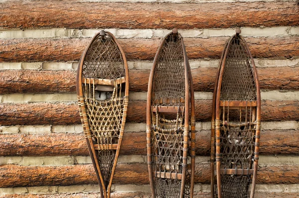 Zapatos de nieve y una cabaña de madera —  Fotos de Stock