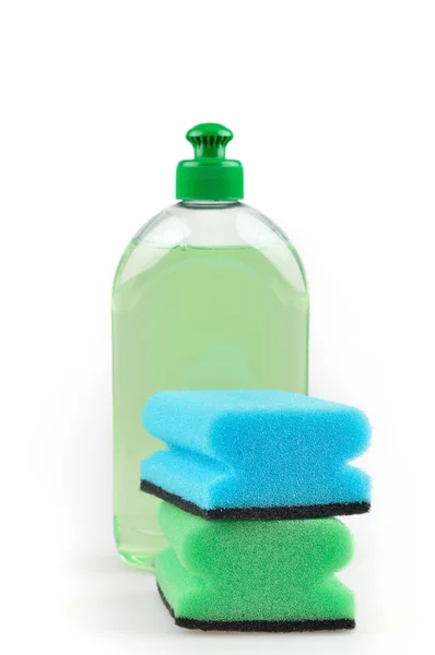 Detergente. Líquido lavavajillas verde y esponjas . — Foto de Stock