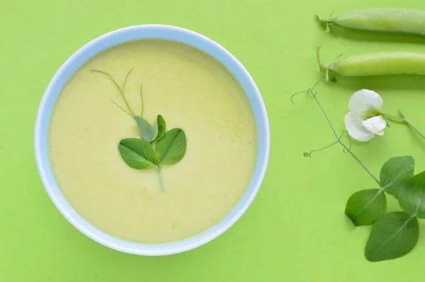 Cold creamy green pea soup and pea pod. — Stock Photo, Image