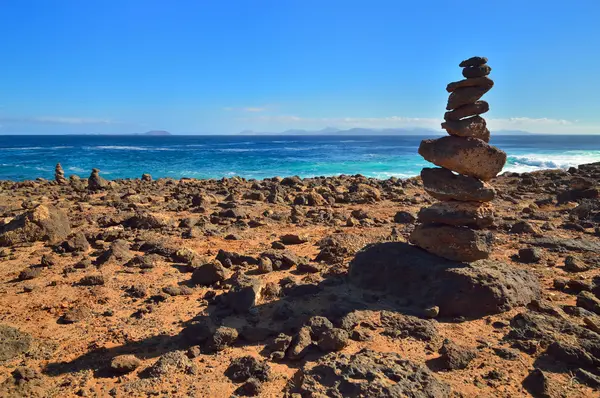 Steinhaufen auf Klippen. Lanzarote, Kanarische Inseln. Steinhaufen auf Klippen. Die Zeit drängt.. — Stockfoto