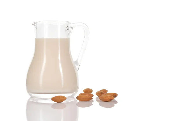 Leche de almendras en jarra sobre fondo blanco . — Foto de Stock