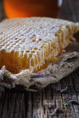 Bal geçmişi. Tarakta tatlı bal, cam kavanoz. Ahşap arka planda