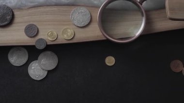 Numismatics. Old collectible coins on a wooden table. Dark background. Top view.
