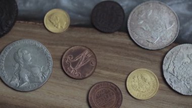 Numismatics. Old collectible coins on a wooden table. Dark background. Top view.