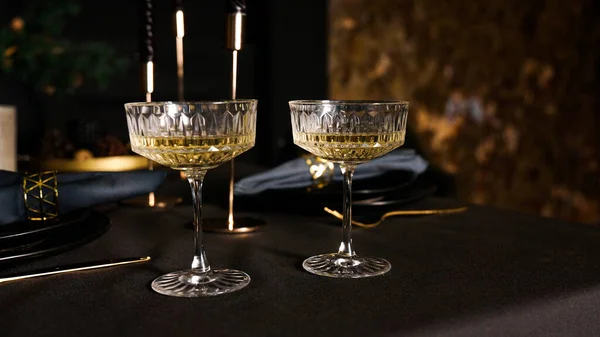 Deux verres à champagne vintage populaires sur un fond sombre de la table servie — Photo