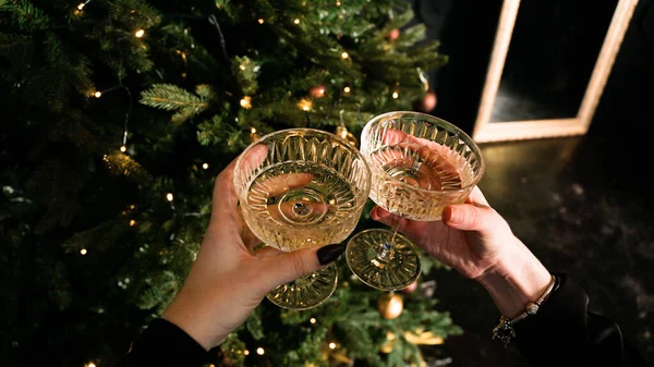 Two people holding vintage glasses of festive champagne on Christmas background — Stock Photo, Image