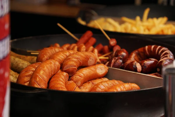 Street food. Grilled sausages at the Christmas market. Fast food — Zdjęcie stockowe