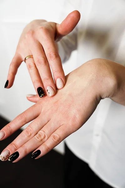 Närbild - ung kvinna som applicerar återfuktande närande olja för händer — Stockfoto
