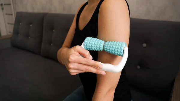 Woman massaging herself with body roller at home — Stock Photo, Image