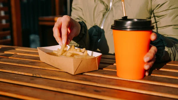 Vrouw die lekkere frietjes eet en thee drinkt in een café. Close-up foto — Stockfoto