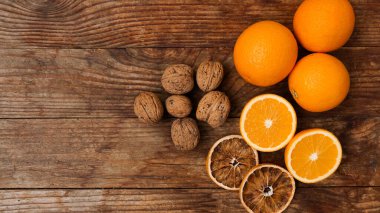 Ahşap arka planda portakal ve ceviz. Yarı yarıya ve kurumuş portakallar
