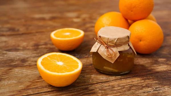 Jar of orange jam on wooden background from top view. Homemade marmalade — Stock Photo, Image