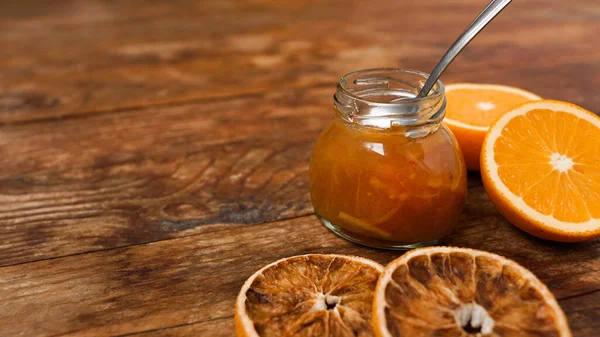 Glas Orangenmarmelade, trockene Orangen auf Holzgrund von oben gesehen. — Stockfoto