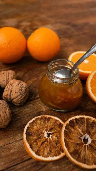 Sweet orange jam or marmalade dessert with walnuts on wooden background — Stock Photo, Image