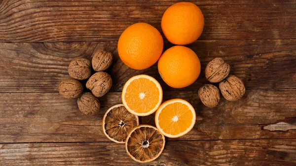 木制背景的橘子和核桃。半身橙和干橙 — 图库照片