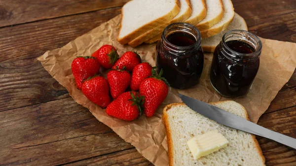 Sandwiches con mantequilla. Frascos de fresa y mermelada sobre mesa de madera. Desayuno —  Fotos de Stock