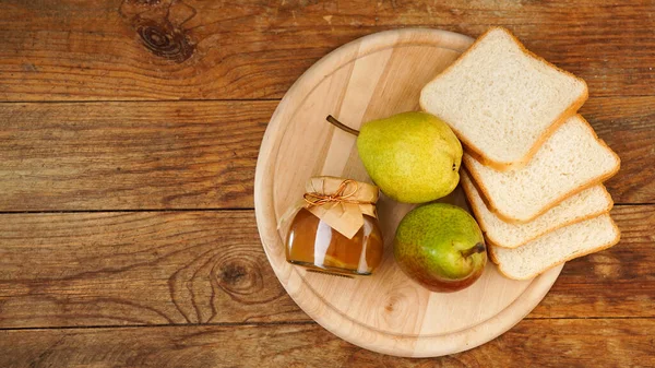 Jarro de engarrafamento de pêra saboroso com pão e fruto de pêra fresco na mesa de madeira. Vista superior — Fotografia de Stock