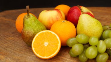 Ahşap zemin üzerinde taze meyveler, armutlar, elmalar, üzümler, yakın plan.