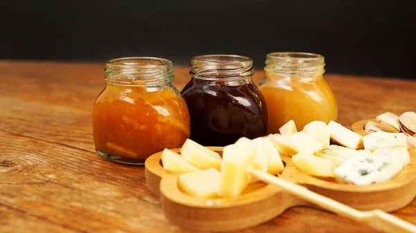 自家製ジャムの瓶や木製のテーブルの上にチーズの様々な。チーズプレート — ストック写真