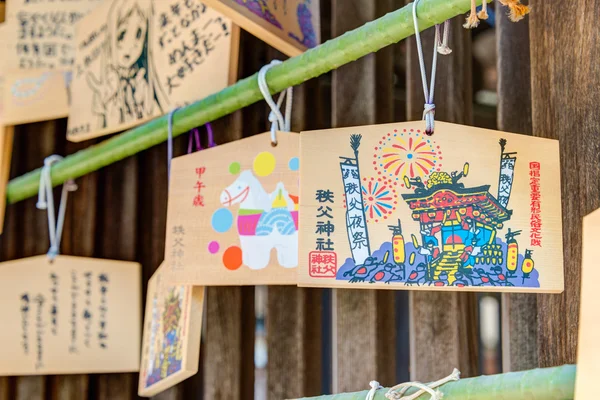 CHICHIBU, JAPÓN - 26 DE ABRIL DE 2014: Tablas de oración de madera en un Santuario Chichibu. Rezar por la felicidad, la buena vida, la salud, la paz, la suerte por escribir la palabra de oración en tableta de madera . — Foto de Stock